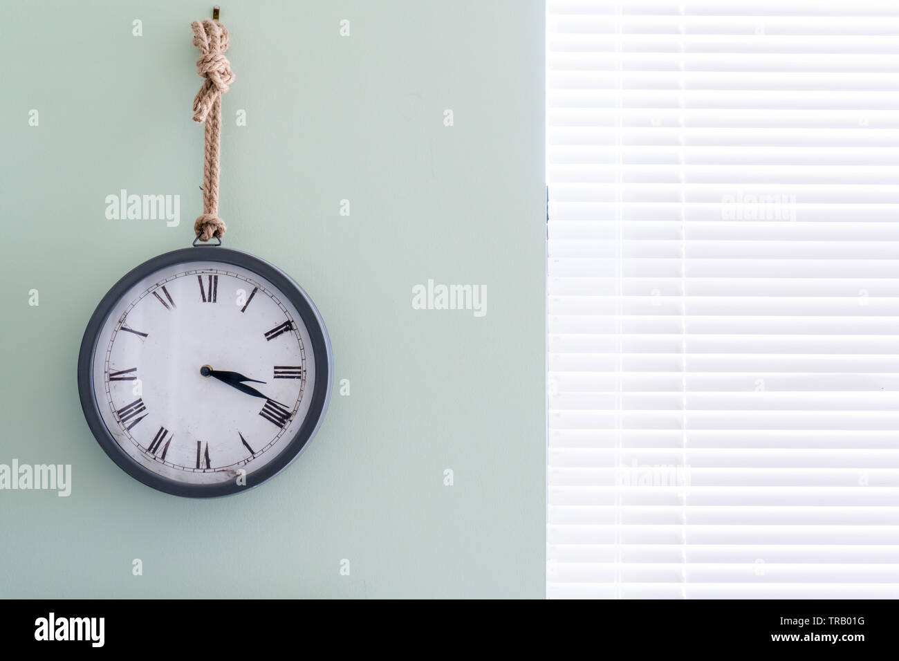 Horloge murale avec nautical design rustique, dans un bureau à domicile, sous forme analogique, en pointant à 3 dans l'après-midi à l'aide de chiffres romains. Banque D'Images