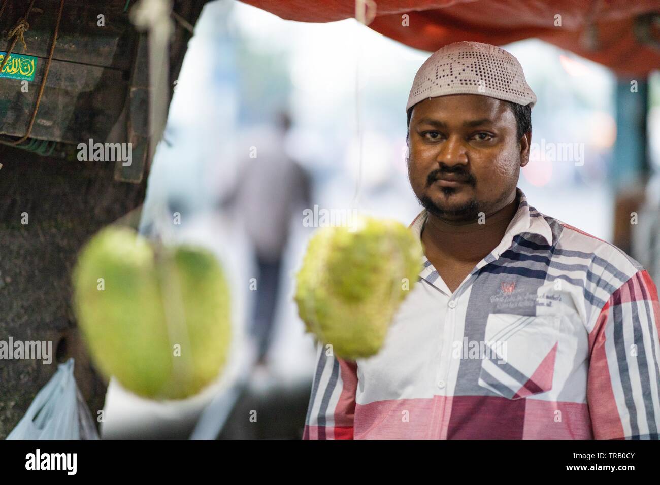 Un vendeur de fruits fruits Corossol vente pose pour une photographie à Hyderabad, Inde Banque D'Images