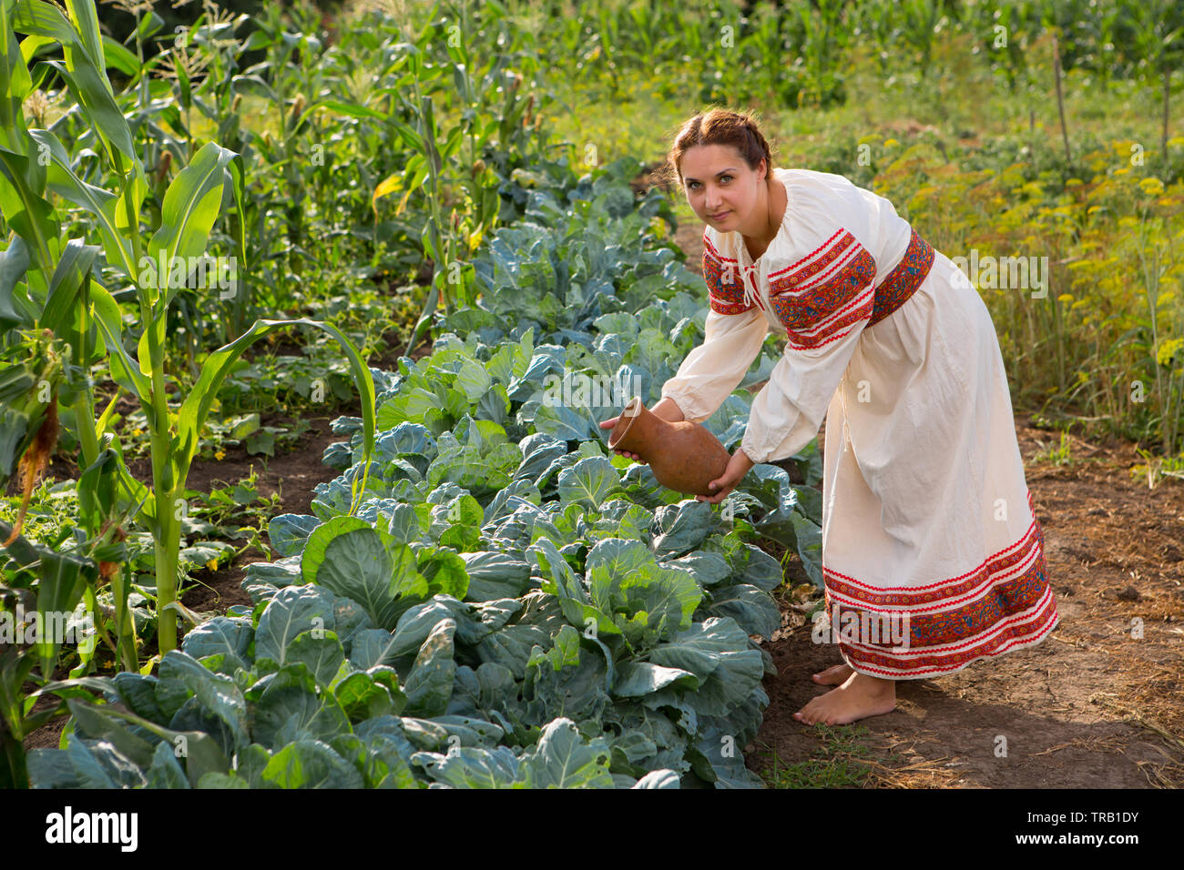 Fille en chemise traditionnelle russe l'arrosage du jardin Photo Stock -  Alamy