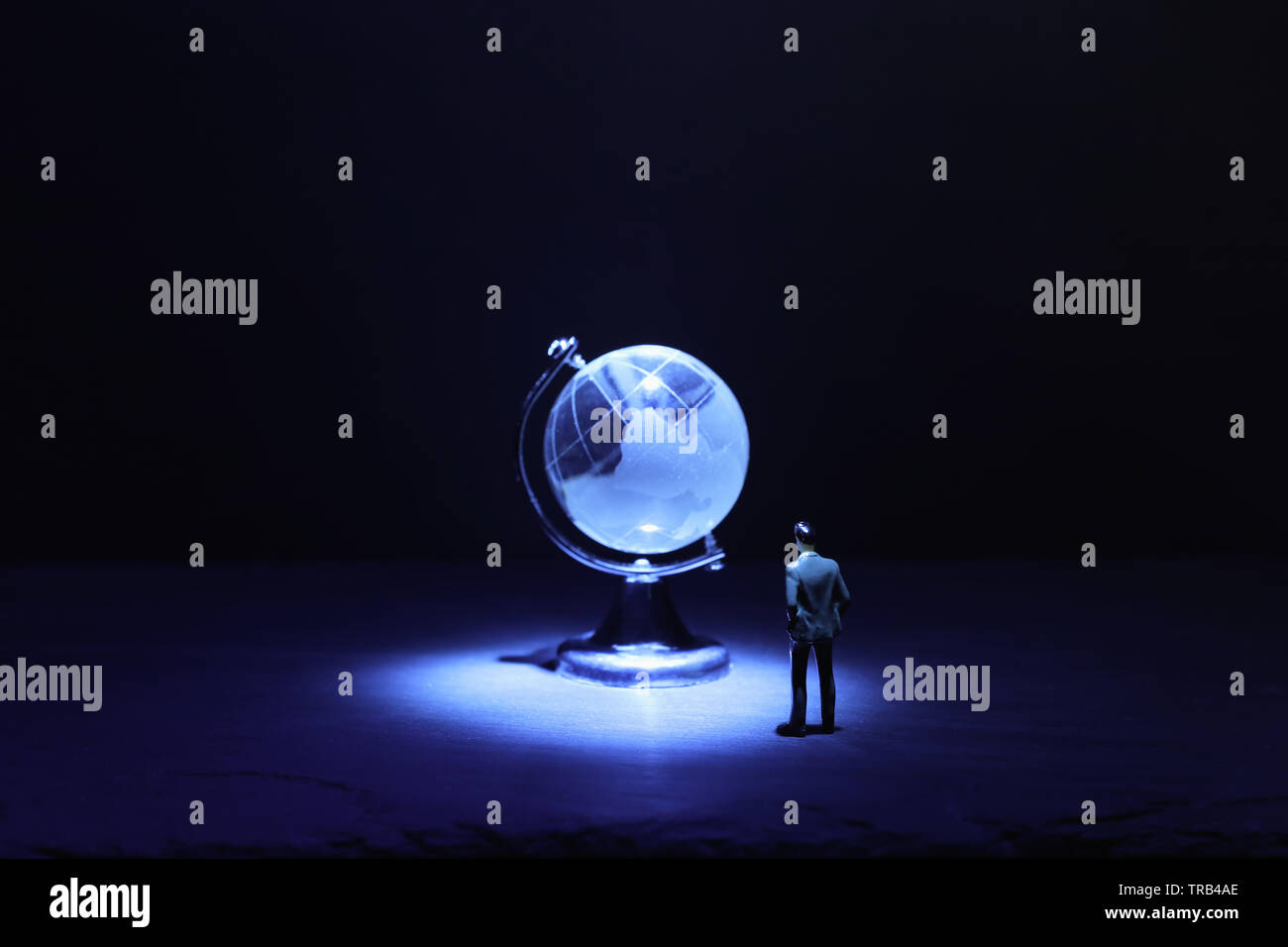 L'homme à la petite miniature au globe de cristal en face de Dark and Light.spectaculaire concept questions mondiales Banque D'Images