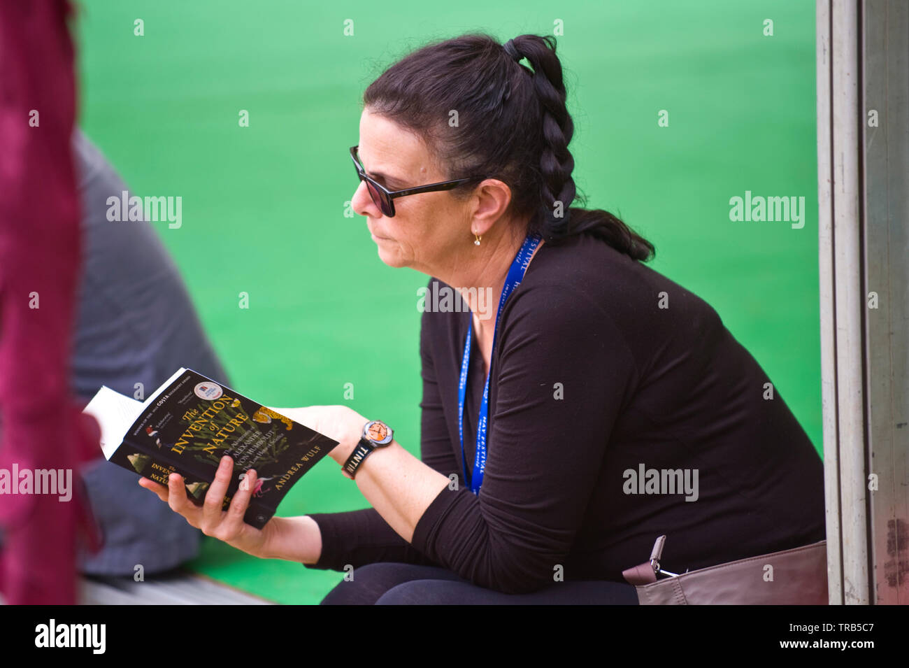 Les visiteurs se détendre et lire des livres sur la pelouse à l'Hay Festival Hay-on-Wye Powys Pays de Galles UK Banque D'Images