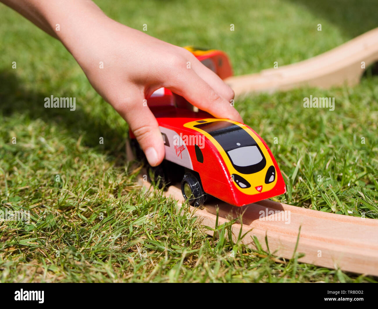 Enfant jouant avec un jouet en bois Brio-style Pendolino Virgin Banque D'Images
