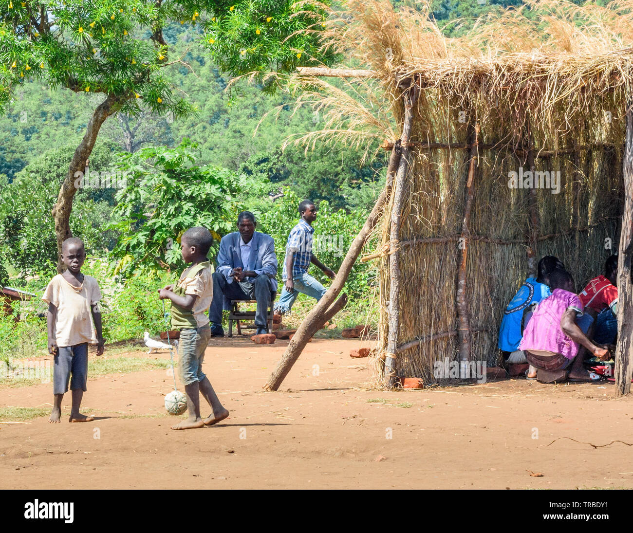 Les garçons jouent avec une balle faite de sacs de plastique et de chaîne dans un village du Malawi Banque D'Images