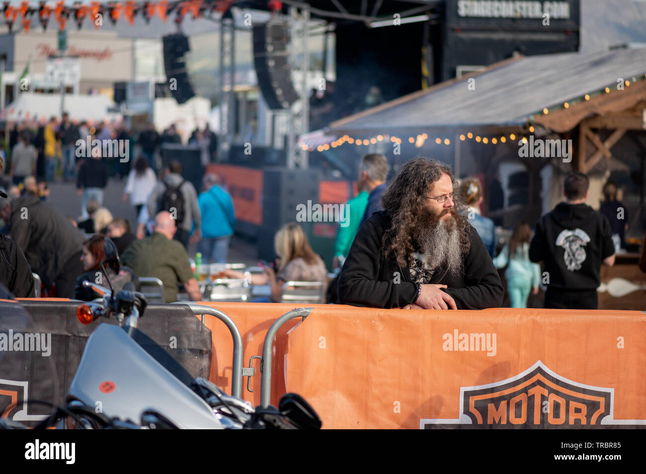 Motard à cheveux longs et barbe regardant les motos Harley Davidson à vendre dans le village de vélos de Killarney lors du rassemblement de la « Harley Davidson » Bike Fest à Killarney, comté de Kerry, Irlande Banque D'Images