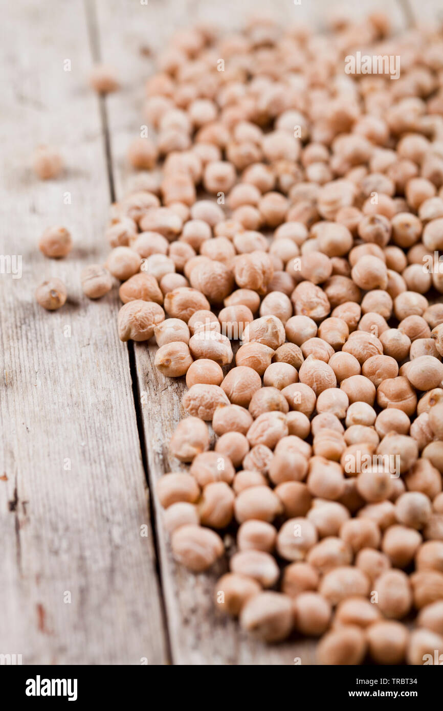 Pois chiches biologiques crus secs heap sur table en bois rustique, arrière-plan. L'alimentation saine avec l'exemplaire de l'espace. Banque D'Images