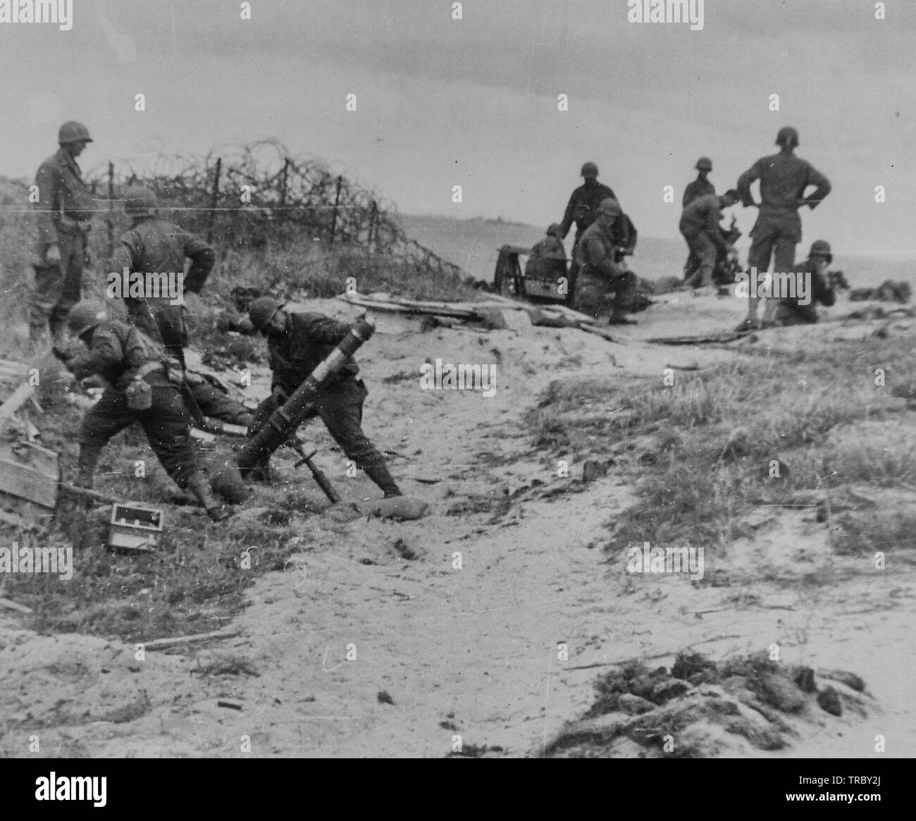 Un équipage de mortier se tient en retrait juste avant de tirer dans une position nazie quelque part le long de la côte normande, en France. 6 juin 1944. Banque D'Images