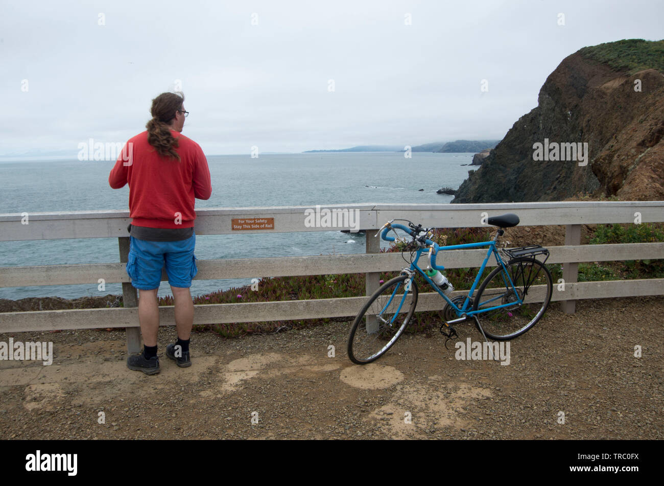 Un jeune homme prend de l'avis d'un Point Bonita dans le Marin Headlands. Banque D'Images
