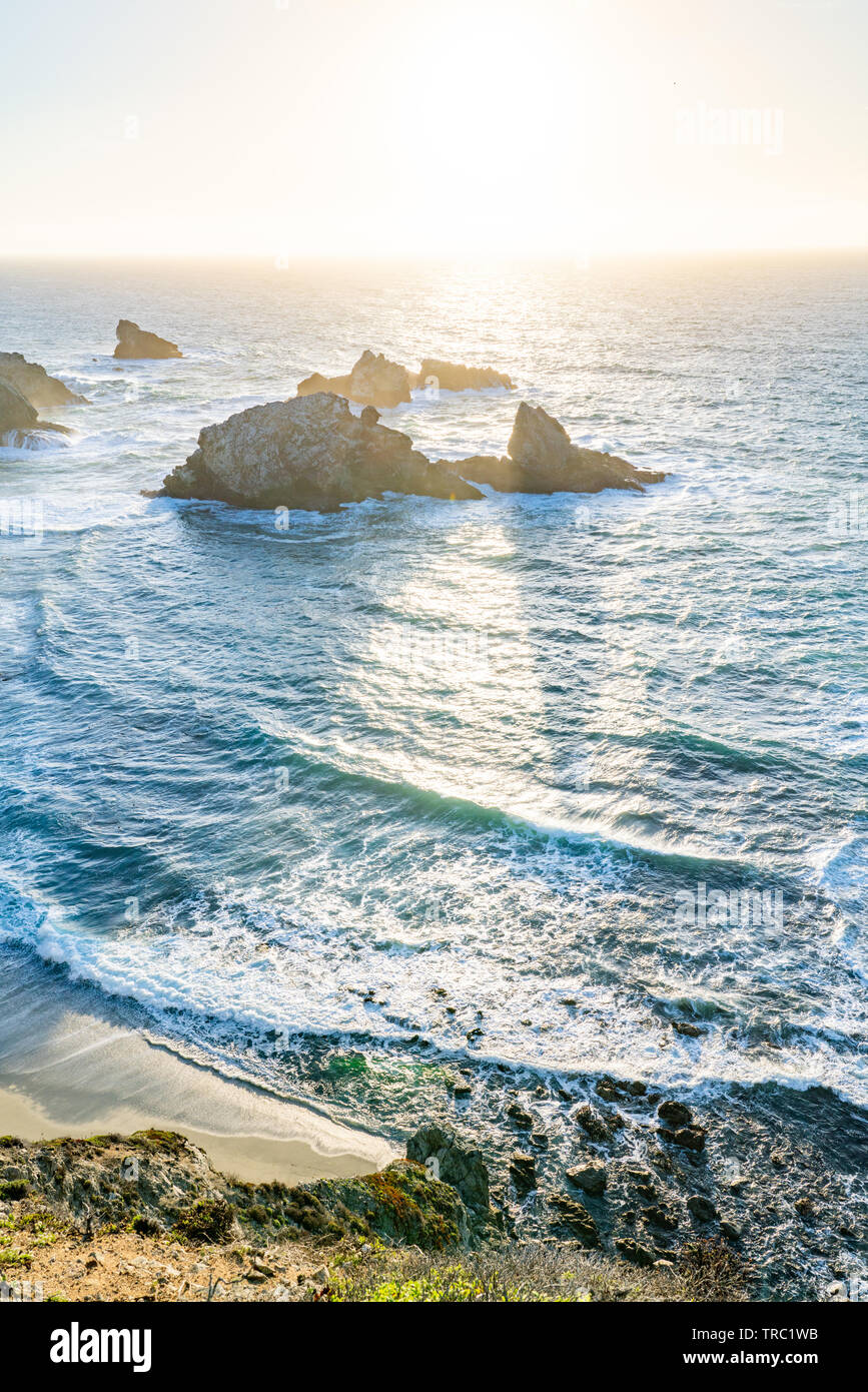 Le soleil crée des ombres derrière les piles de la mer le long d'un littoral magnifique, Big Sur, Californie, USA. Banque D'Images