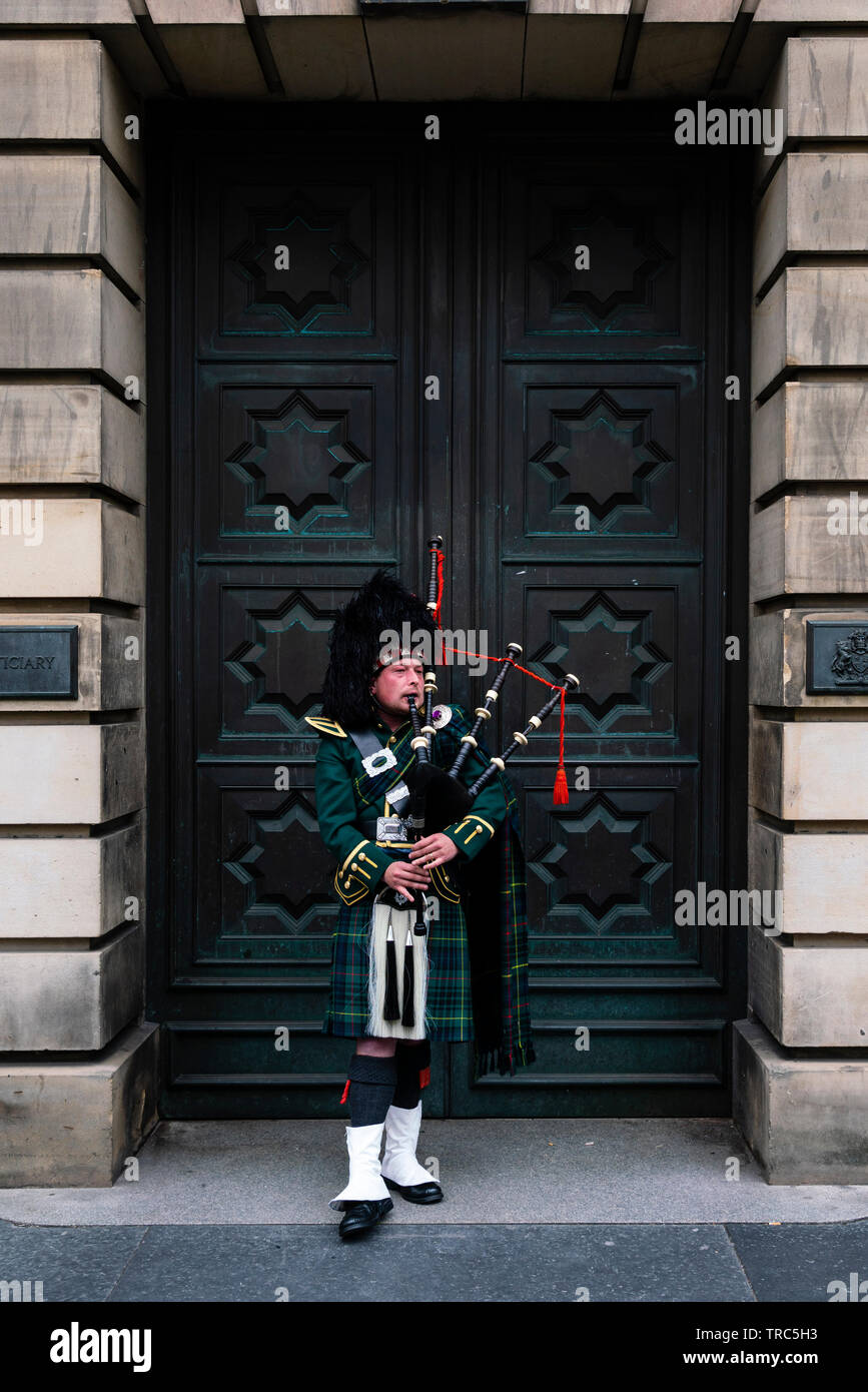 Piper écossais jouer de la cornemuse sur Royal Mile d'Édimbourg à l'extérieur de la Haute Cour de la vieille ville d'Édimbourg, Écosse, Royaume-Uni Banque D'Images