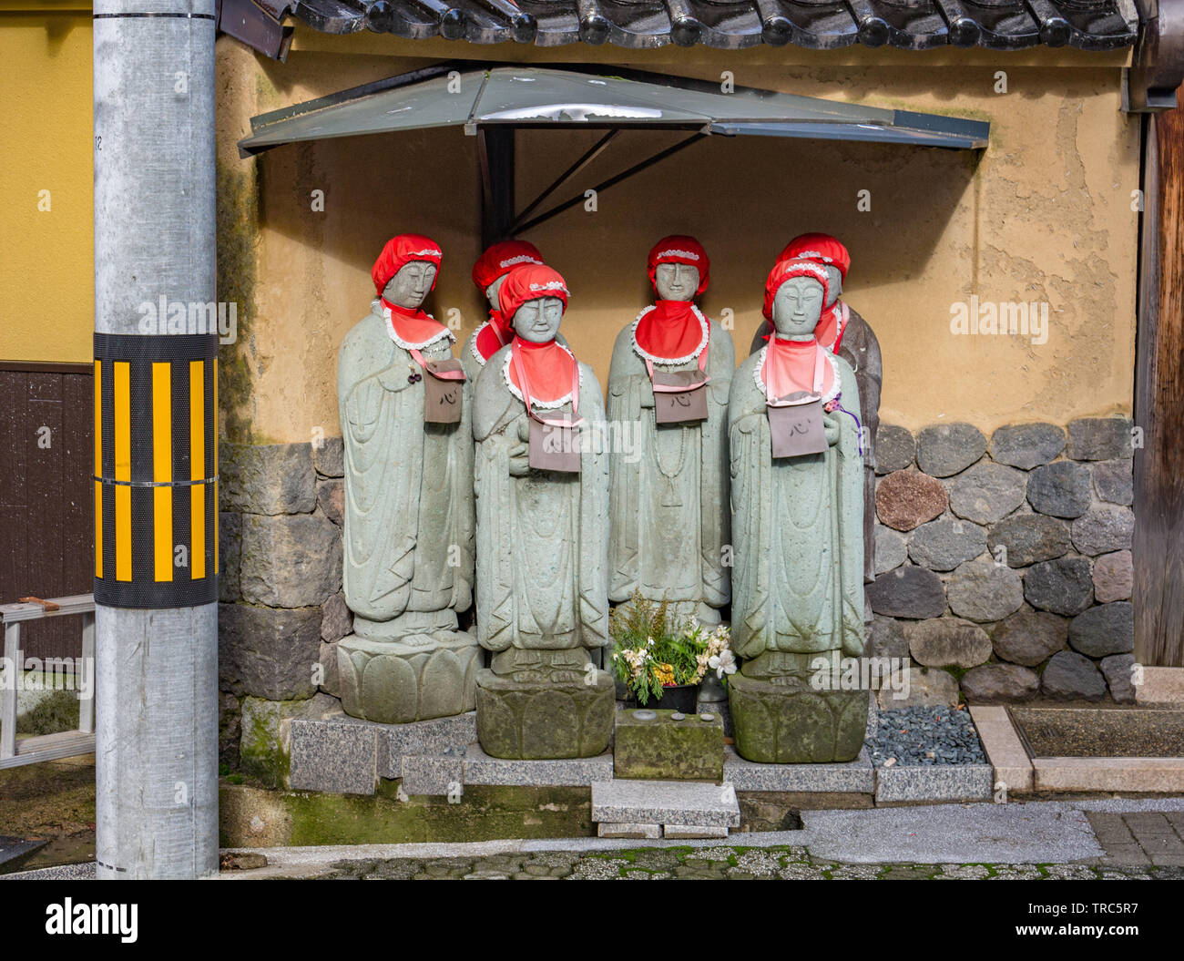 Six statues de pierre Ojizou san wearing red cap et bib, protecteur des enfants et le protecteur des voyageurs, dans un temple, au Japon. Banque D'Images