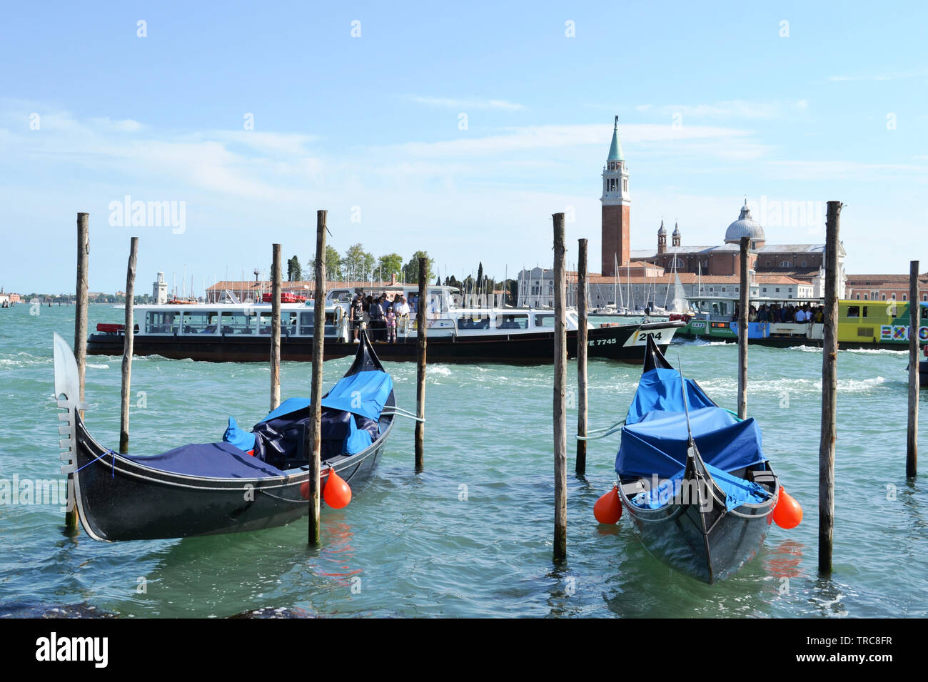 Venise/Italie - 8 mai 2015 : une vue panoramique sur la lagune de Venise, San Giorgio Maggiore island, deux gondoles ancrées à poteaux et de navire à passagers. Banque D'Images