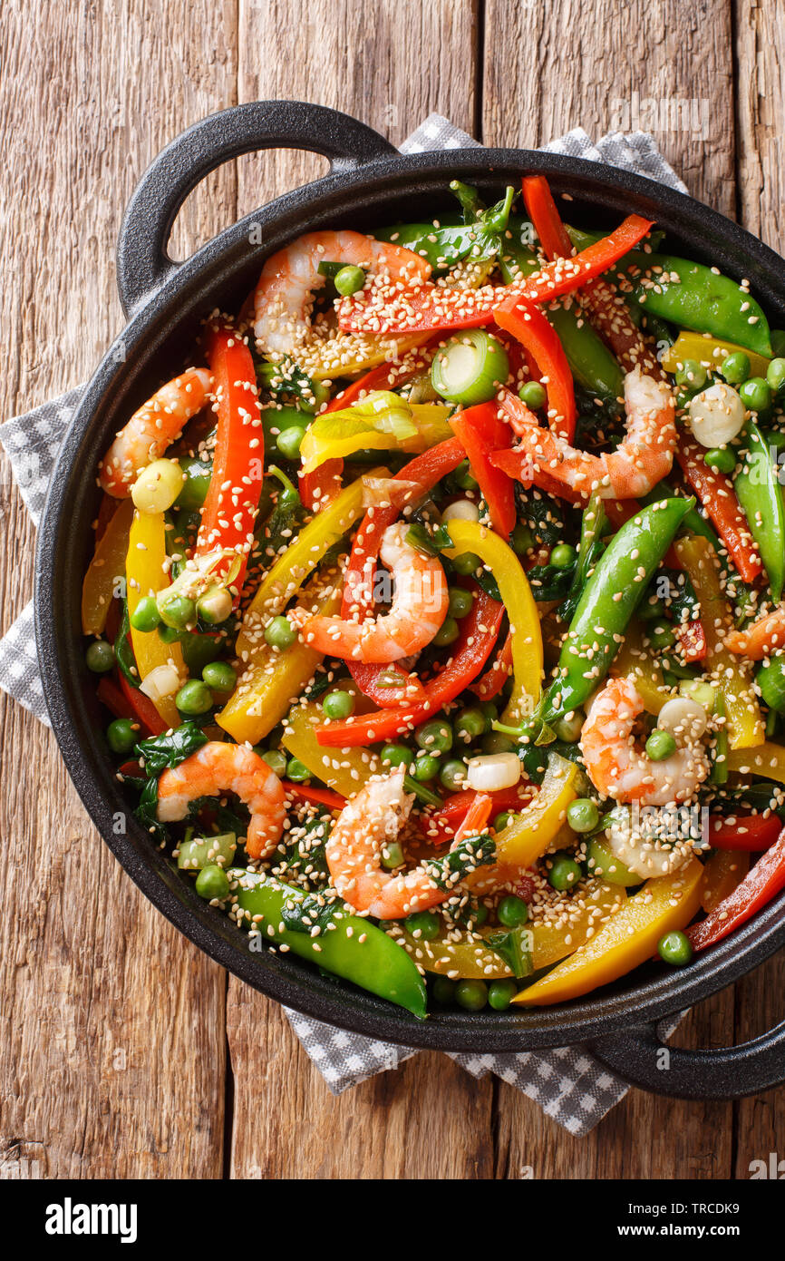 Crevettes sauté aux légumes, close-up de sésame dans une poêle sur la table. Haut Vertical Vue de dessus Banque D'Images