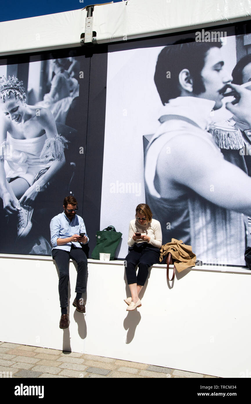 Photo de Londres, Somerset House, Londres. Les visiteurs s'asseoir au soleil en face de photos par Mary McCarthy. Banque D'Images
