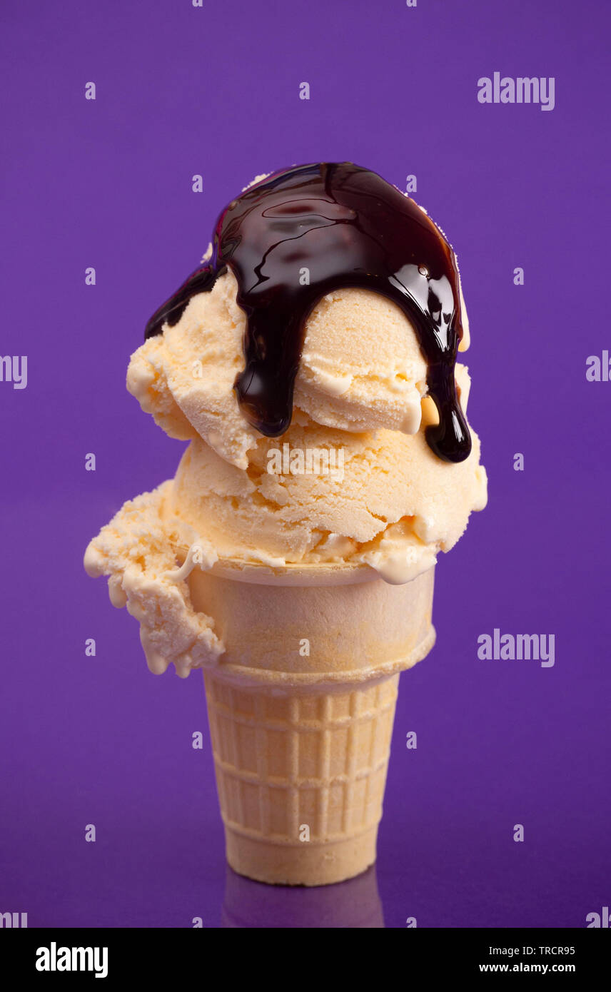 Pelle à double cône de glace à la vanille sur fond violet Banque D'Images