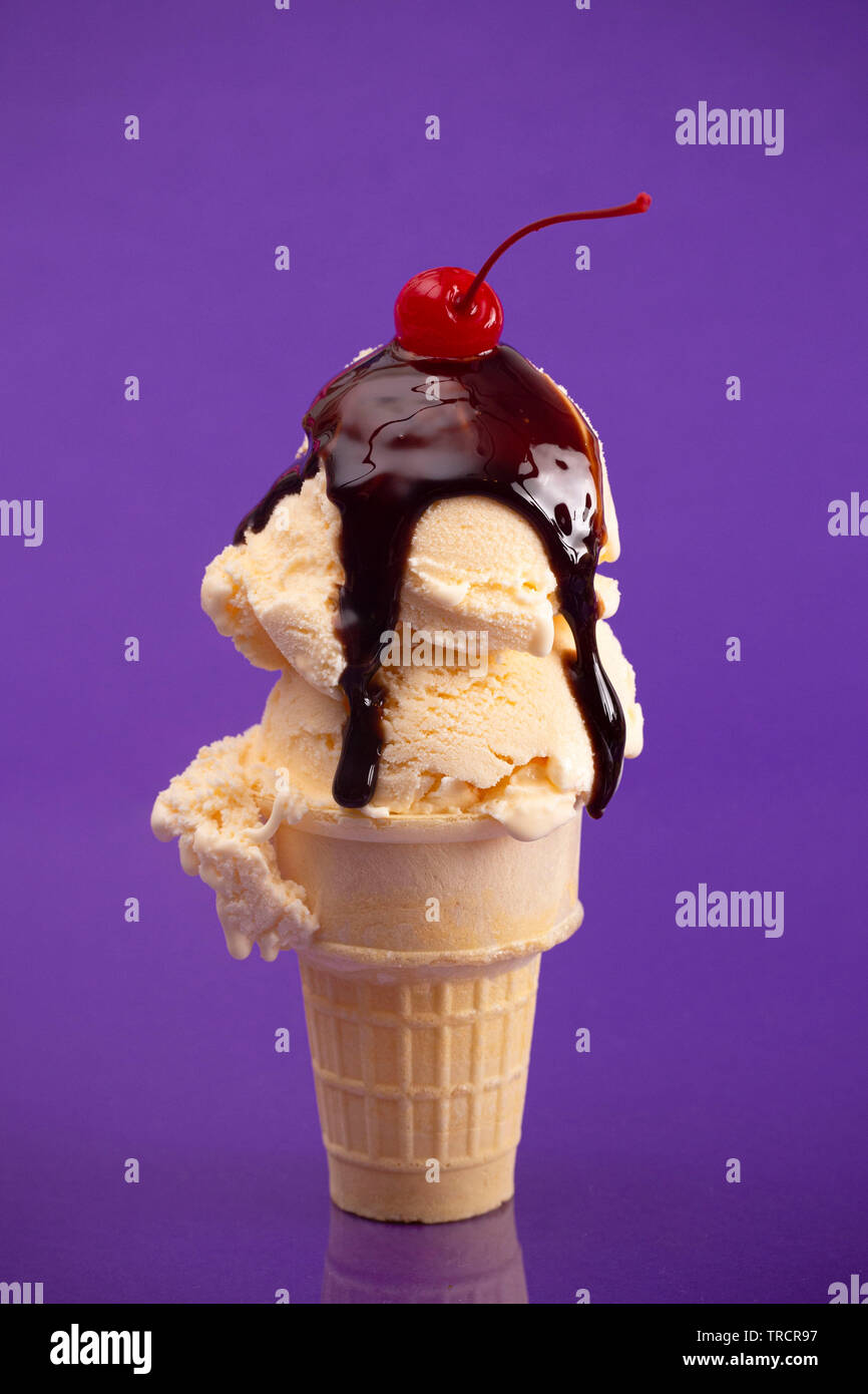 Pelle à double cône de glace à la vanille sur fond violet Banque D'Images