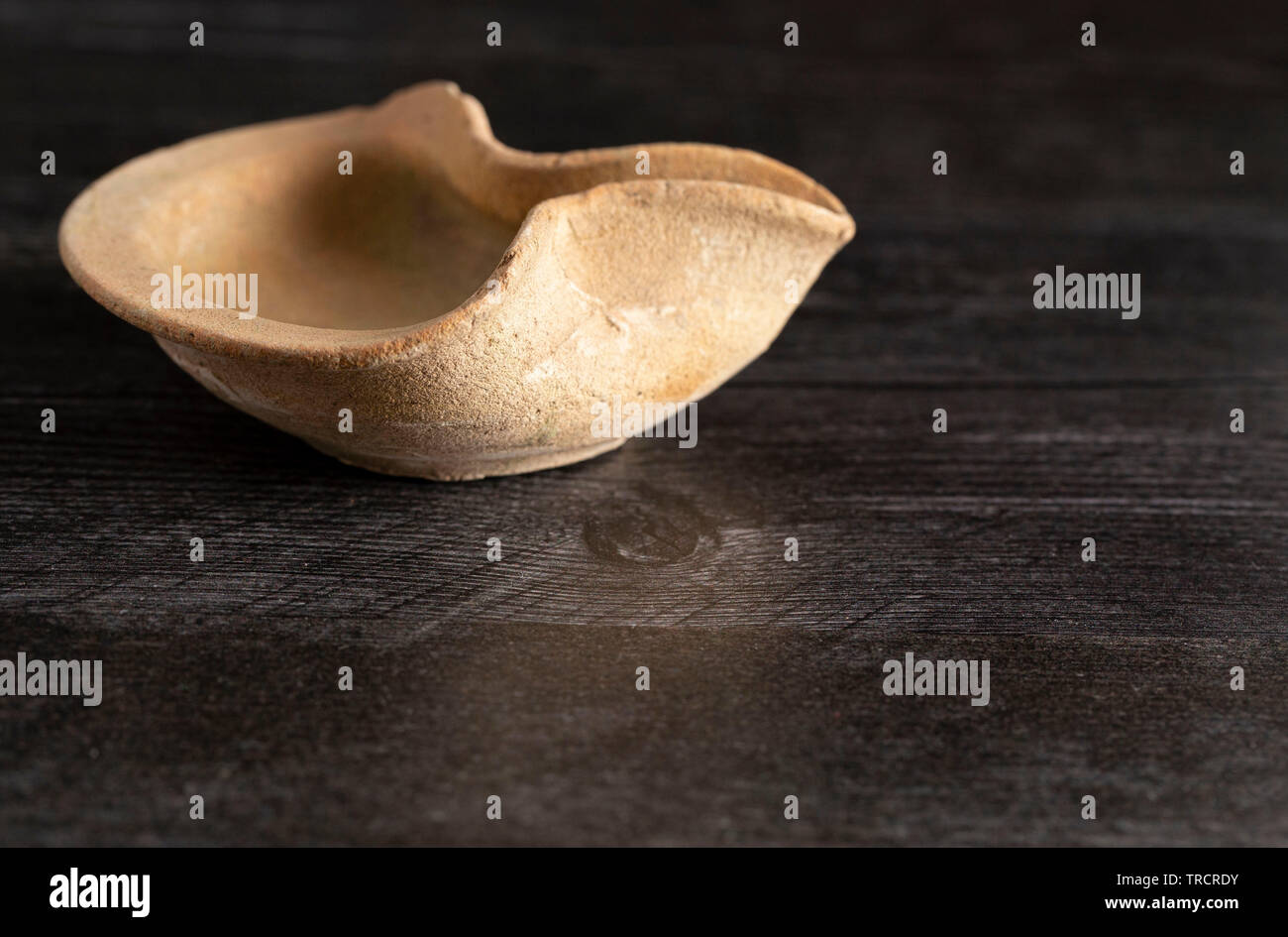 Lampe à huile à la main du Moyen-Orient sur une table en bois sombre. Banque D'Images