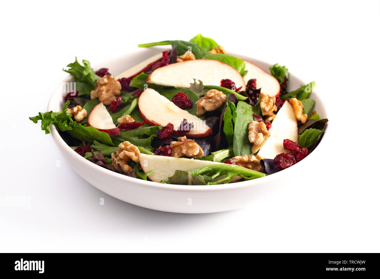 Salade de pommes et canneberges et au noix sur un lit de feuilles vertes mixte Banque D'Images