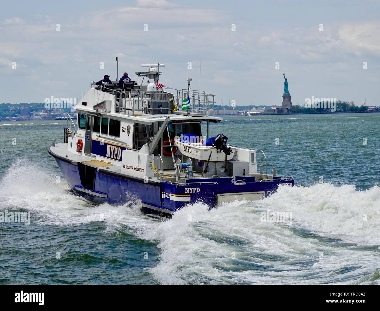 Bateau de la Police de New York P.O. Joseph P. McCormack, dans le port de New York en passant la Statue de la liberté, Manhattan, New York, NY, USA Banque D'Images