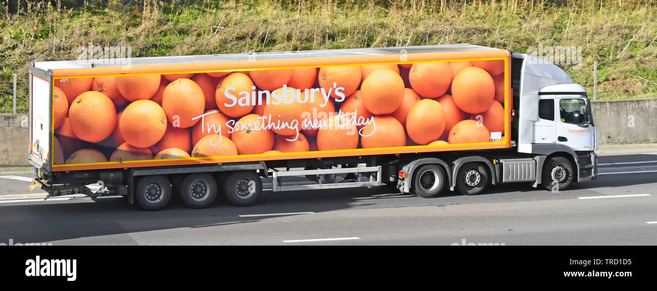 Vue latérale du supermarché Sainsburys poids lourds entreprise chaîne d'approvisionnement alimentaire camion de livraison camion remorque articulée des oranges sur la publicité d'autoroute England UK Banque D'Images