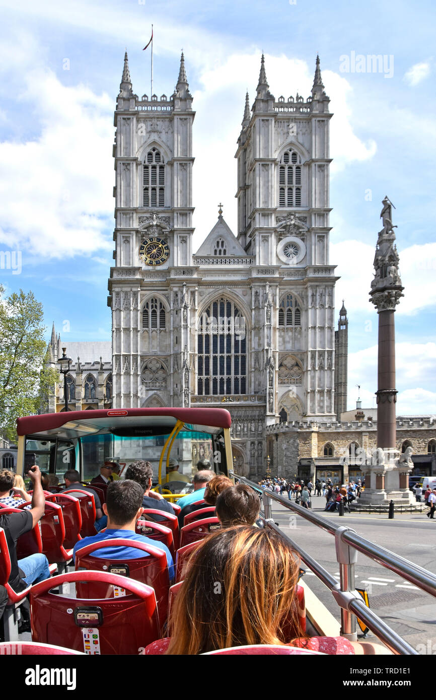 Open top double decker bus touristique Visite guidée d'été sur les passagers à l'avant de l'ouest l'abbaye de Westminster avec les universitaires La guerre colonne commémorative London UK Banque D'Images