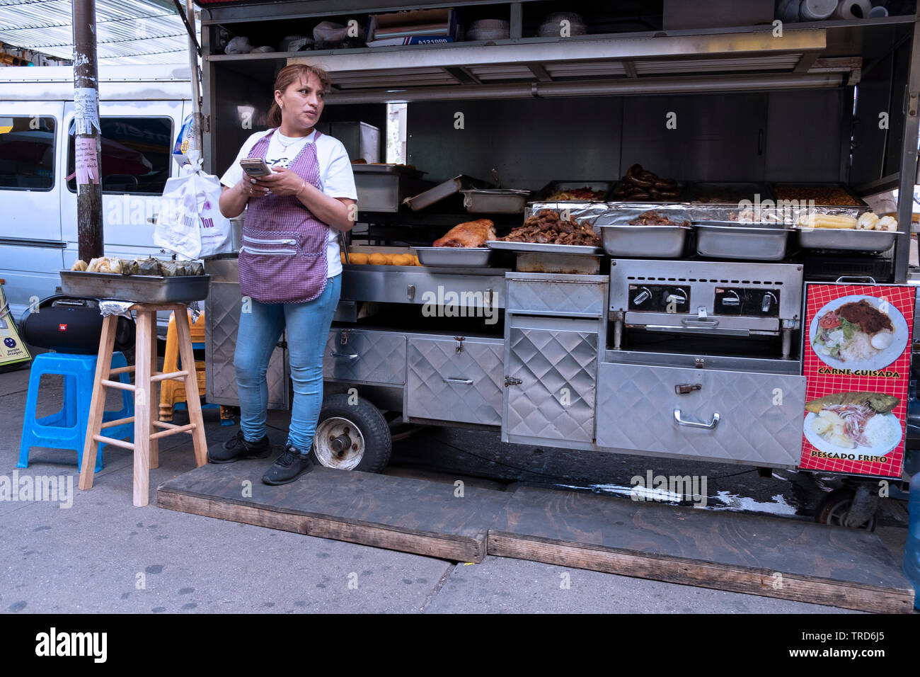 Photo d'une femme franche food vendor sous le métro surélevé sur l'avenue Roosevelt à Jackson Heights, Queens, New York. Banque D'Images
