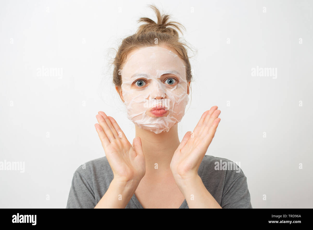 Jeune femme de race blanche avec masque facial blanc froissé sur son visage Banque D'Images