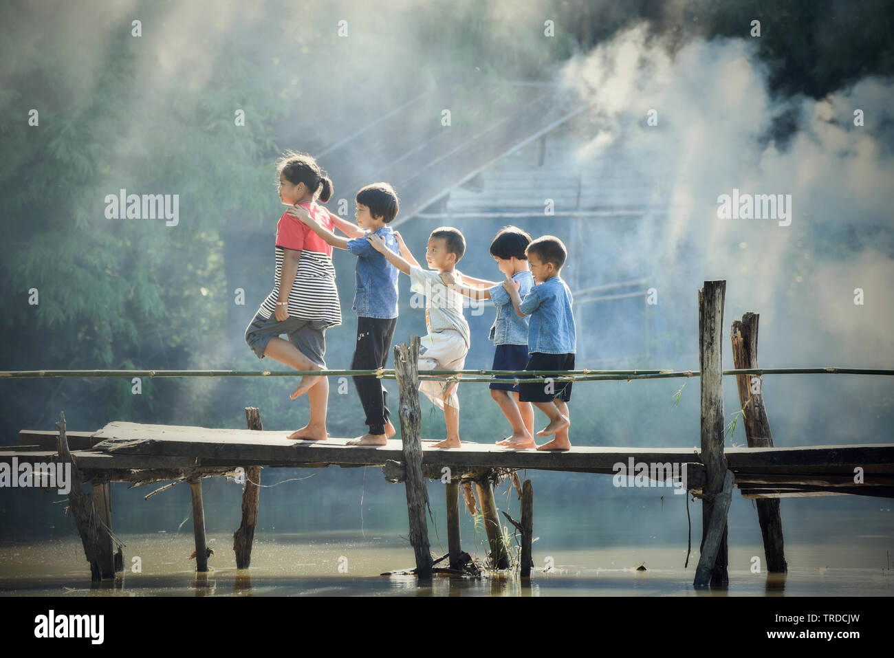 La Thaïlande de sakhon Nakhon - 31 juillet 2018 : Asie enfants garçon et fille ami happy funny sourire et marcher sur la rivière pont bois ferme agricole pays Banque D'Images