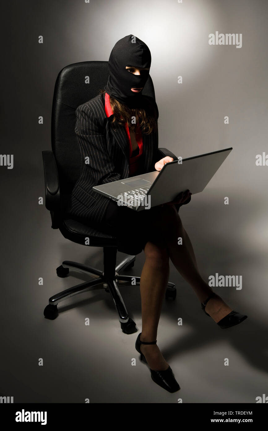 Portrait d une femme d affaires portant un masque de ski et travailler avec un ordinateur portable La cybercriminalite Photo Stock Alamy