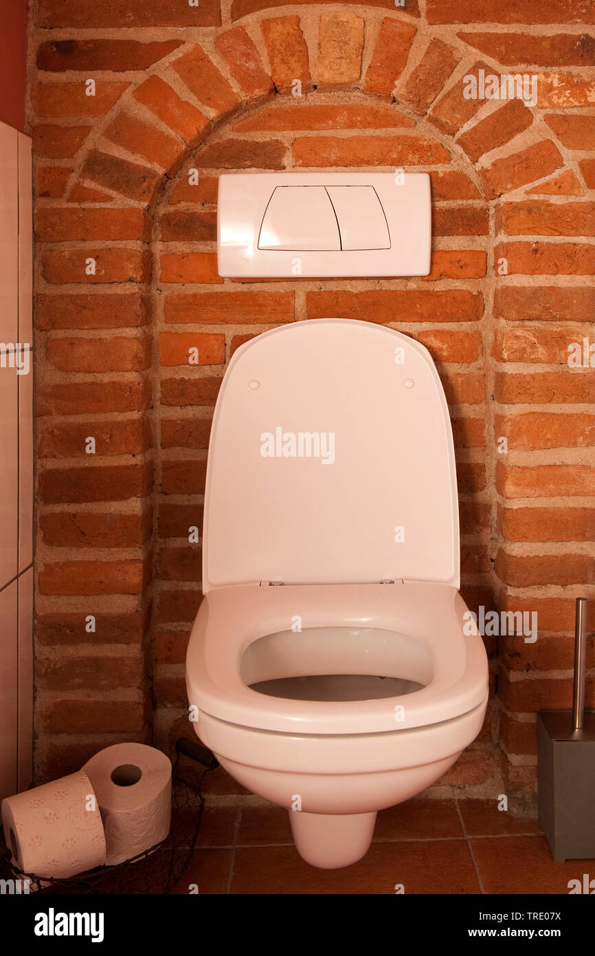 Au mur toilettes installé sur un mur de brique rouge Banque D'Images