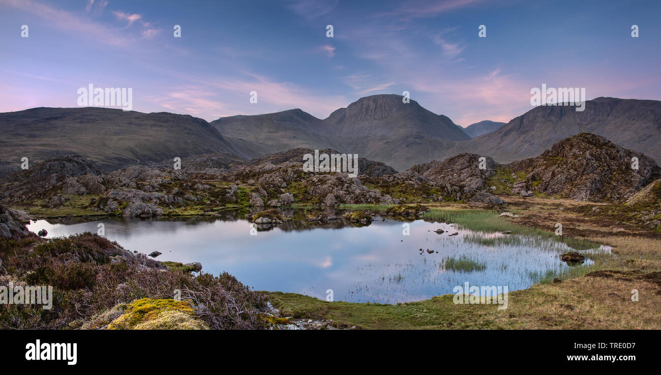 La chaude lumière du matin sur la montagne de Lakeland Grand Gable reflétant en Tarn innommé Banque D'Images