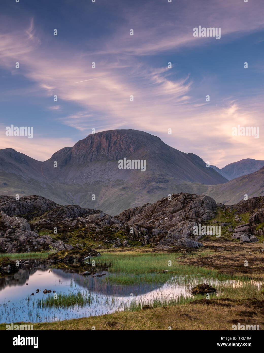 La chaude lumière du matin sur la montagne de Lakeland Grand Gable reflétant en Tarn innommé Banque D'Images