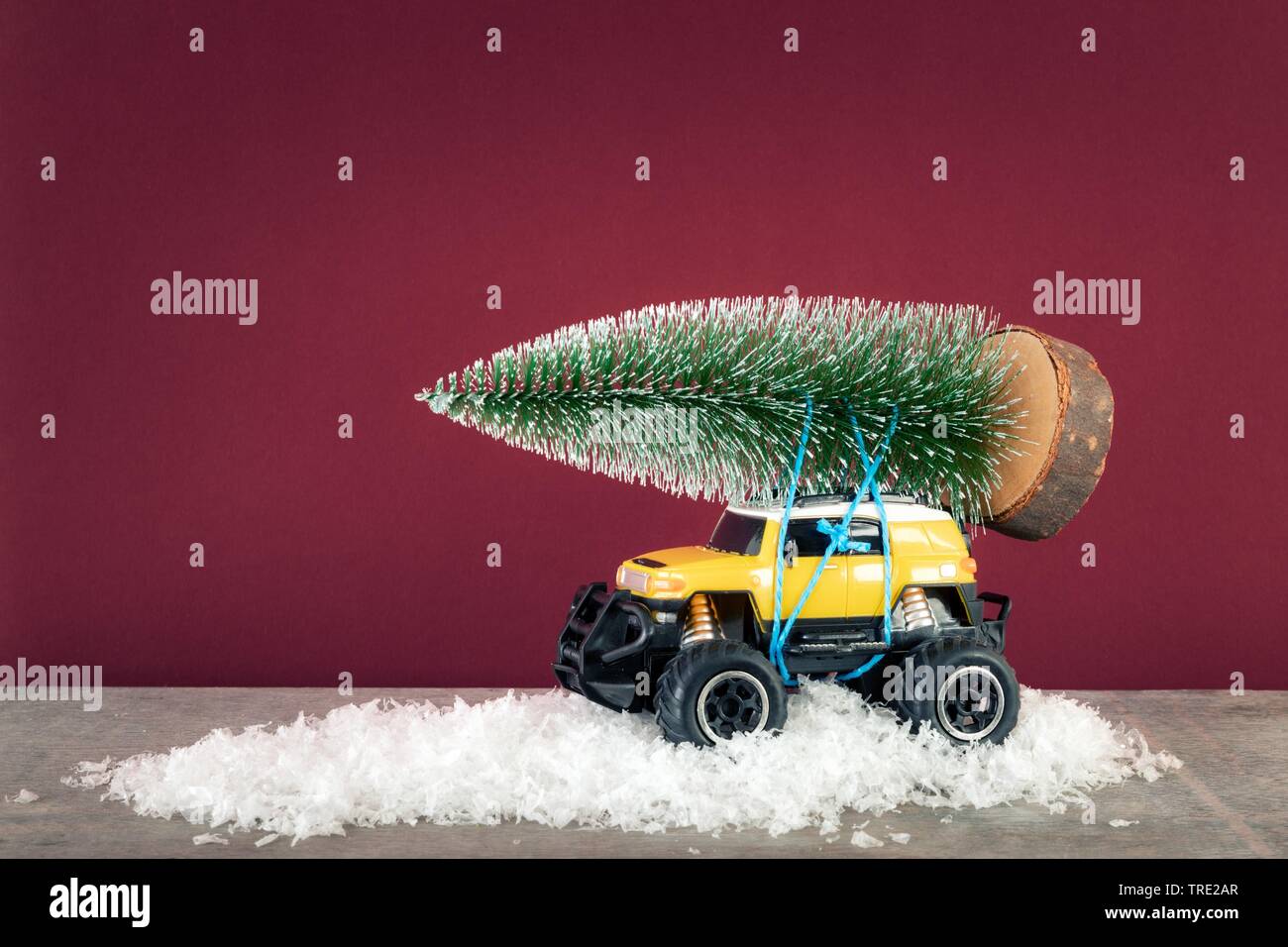 SUV jaune monster voiture camion jouet avec sapin Banque D'Images
