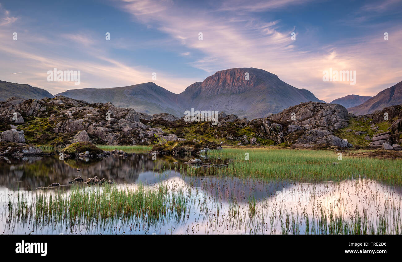 La chaude lumière du matin sur la montagne de Lakeland Grand Gable reflétant en Tarn innommé Banque D'Images