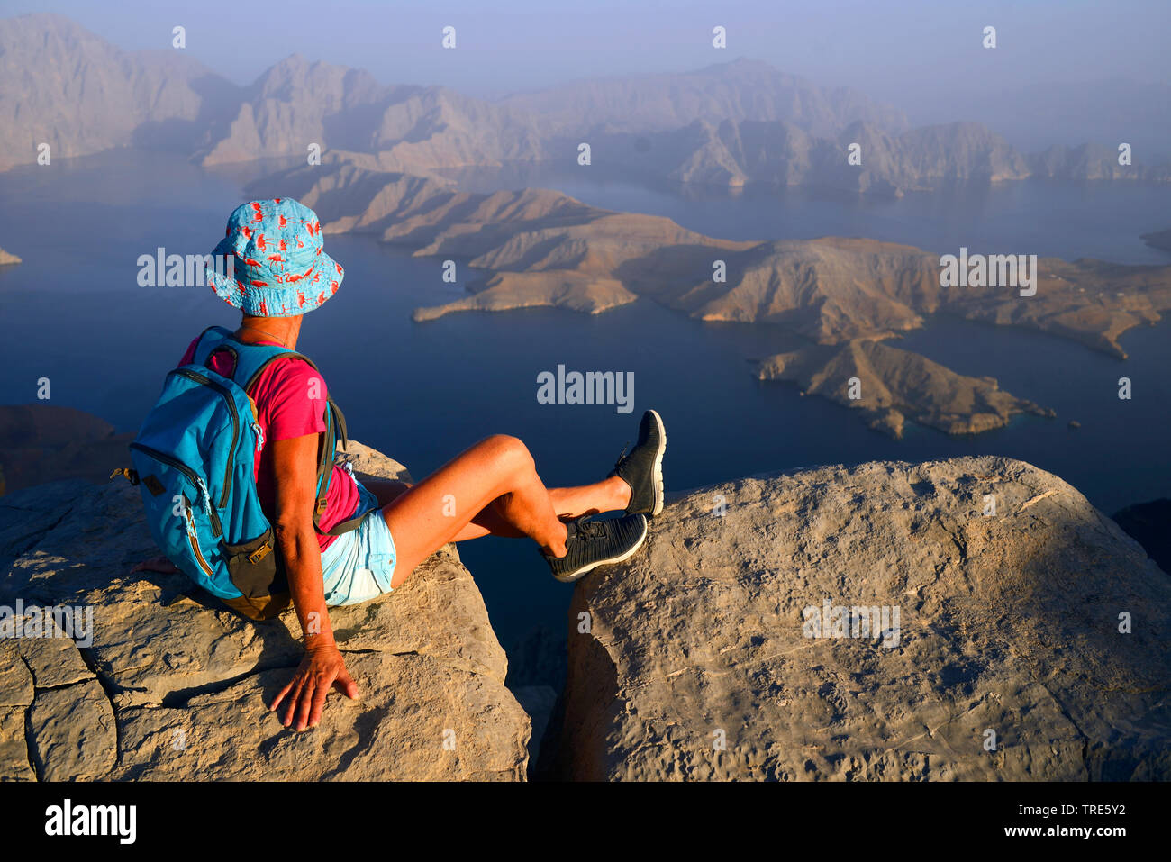 Wanderer femme profitant de la vue depuis une haute montagne à la baie de Sham, Oman, Khasab Banque D'Images