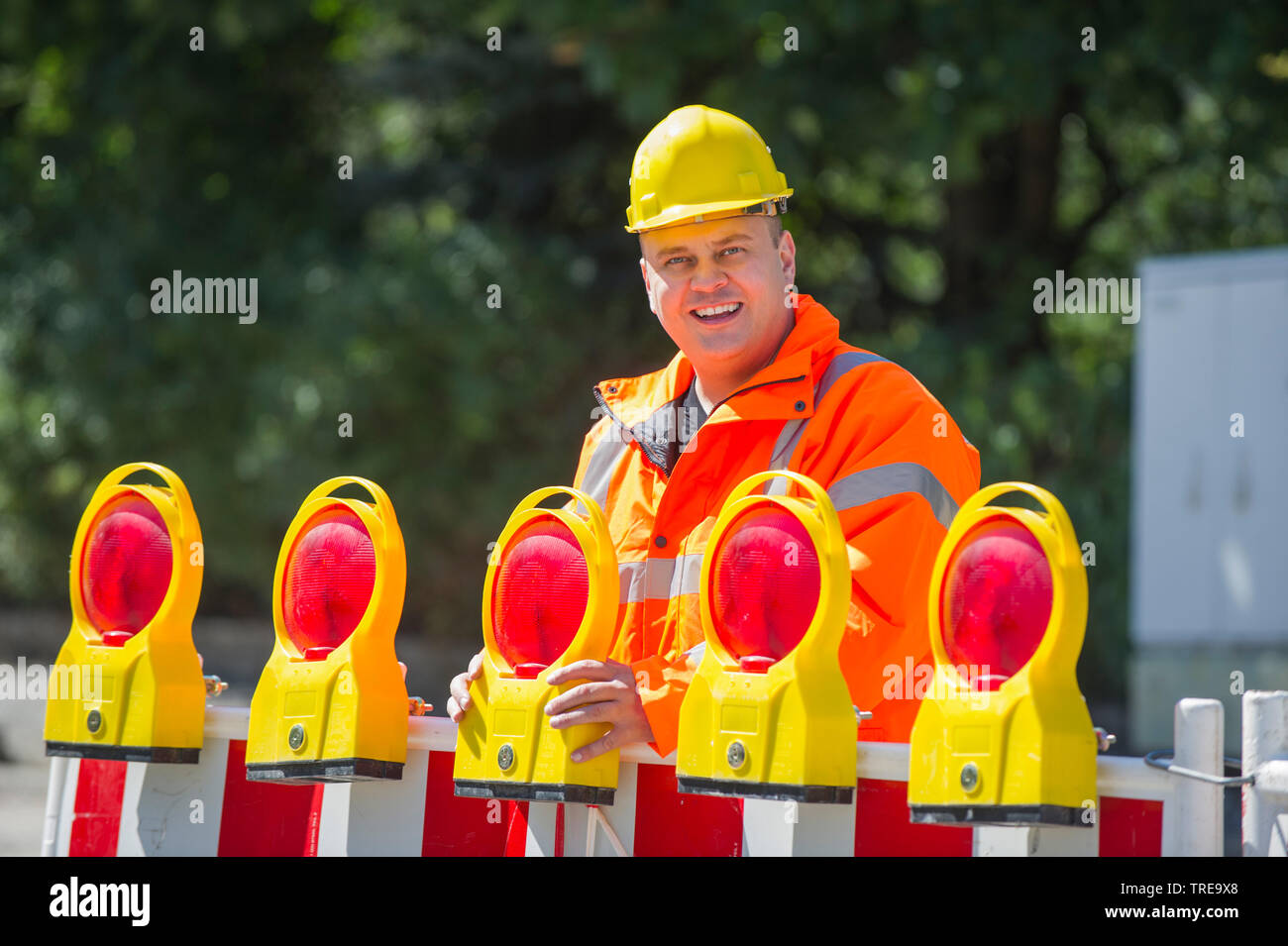 Travailleur de la construction d'une veste haute visibilité orange, l'installation d'un barrage routier avec la construction de détresse Banque D'Images