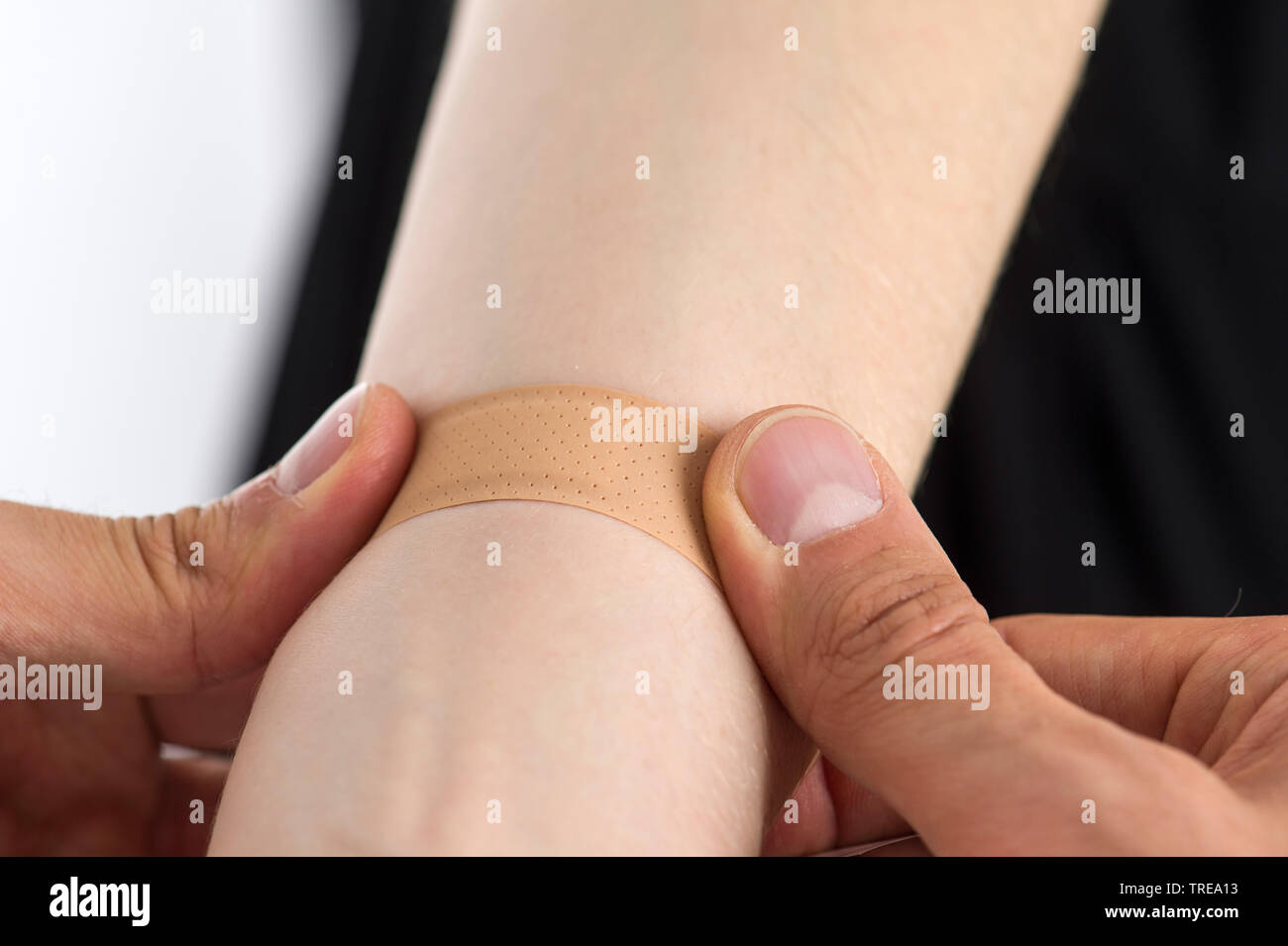 Close up d'un médecin de placer un pansement sur l'avant-bras d'une femme Banque D'Images