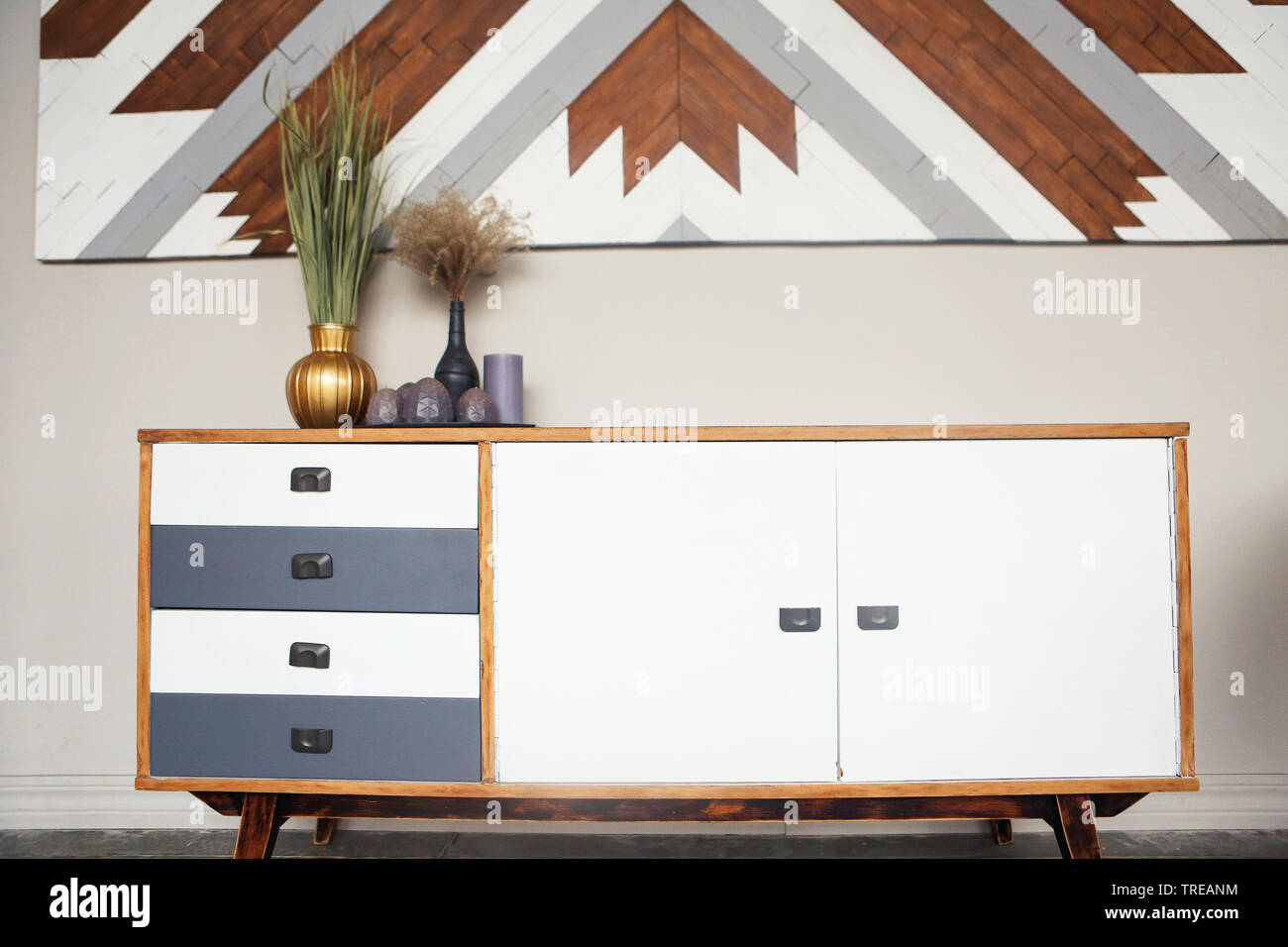 Une partie de la pièce, une commode en bois vintage de vases et de bougies contre les murs clairs. Éléments de design d'intérieur Banque D'Images