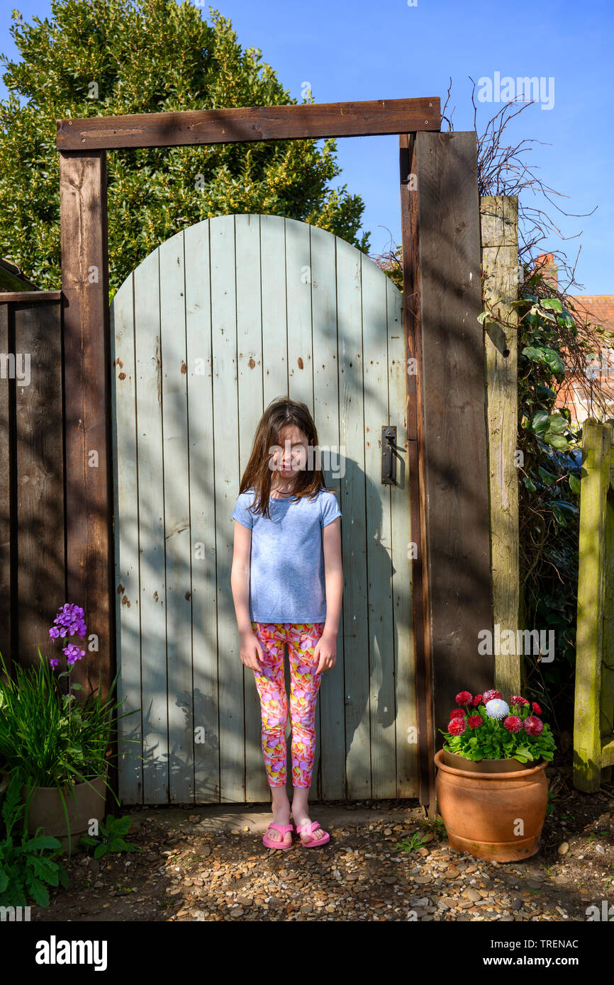 7 ans jeune fille à la porte du jardin Banque D'Images