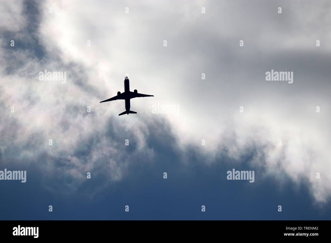 Vol d'un avion dans le ciel. Silhouette d'un avion de passagers décollant sur fond de nuages de tempête Banque D'Images