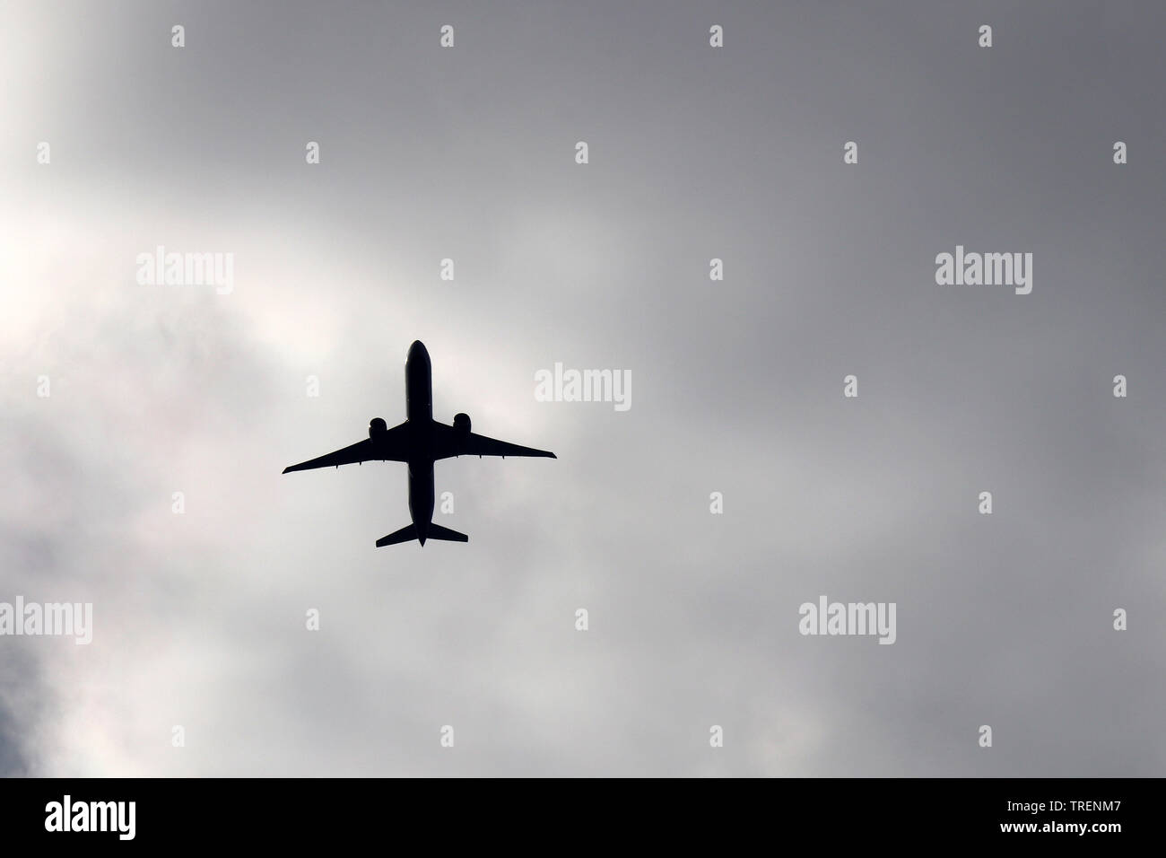 Vol d'un avion sur les nuages de tempête. Silhouette d'un avion du passager dans le sombre ciel dramatique Banque D'Images