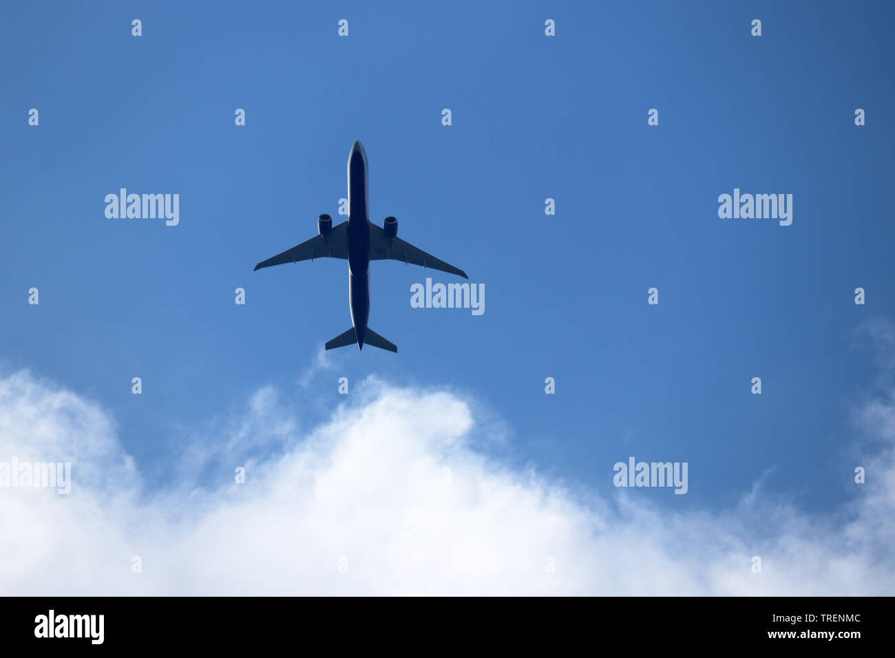 Avion dans le ciel bleu avec des nuages blancs. Avion commercial dans un vol de près, vue de dessous Banque D'Images
