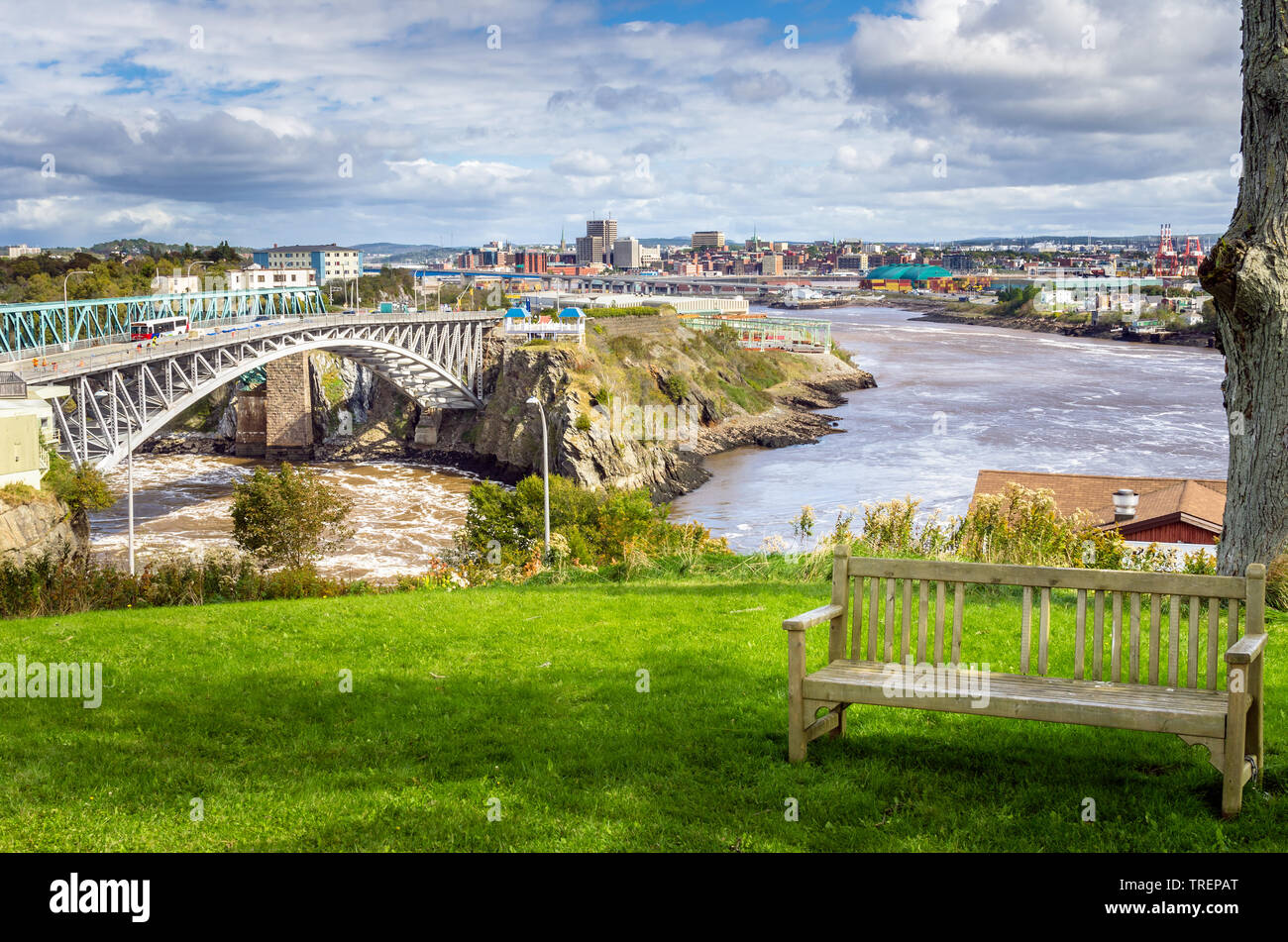 De Saint John, au Nouveau-Brunswick, du Reversing Falls Park avec un banc en bois en premier plan sur un jour d'automne partiellement nuageux Banque D'Images