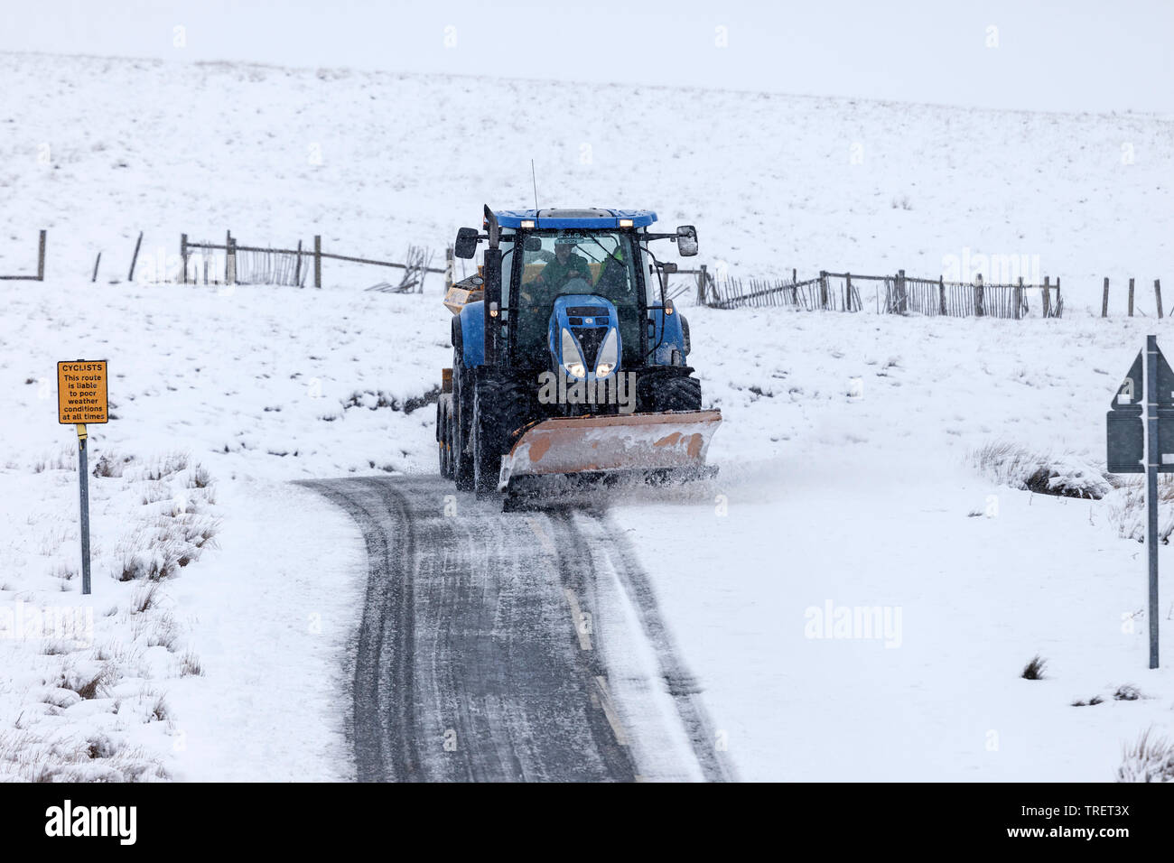 Chasse-neige, l'élimination d'un haut niveau à distance de route de campagne avec un panneau d'avertissement pour les cyclistes d'une mauvaise météo, Teesdale, County Durham, Royaume-Uni Banque D'Images