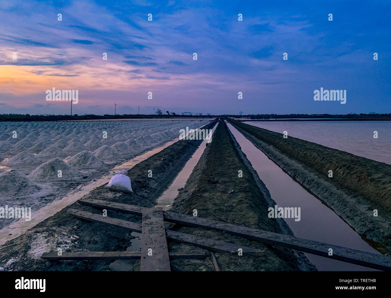 Ferme de sel le matin avec le lever du soleil Ciel et nuages. Paysage de  champ de sel de mer en Thaïlande. L'eau de mer en canal et en voie de sol