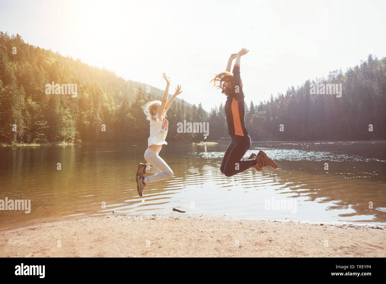 Été - famille heureuse sur une randonnée. Fun heureux famille sautant sur le rivage d'un lac de montagne synevyr. Banque D'Images