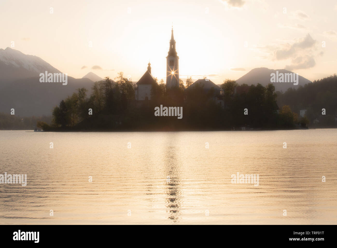 Le lac de Bled à l'église d'ossature. La première lumière du soleil qui brillait à travers la fenêtre de la tour de l'église Moody scène de matin calme Banque D'Images