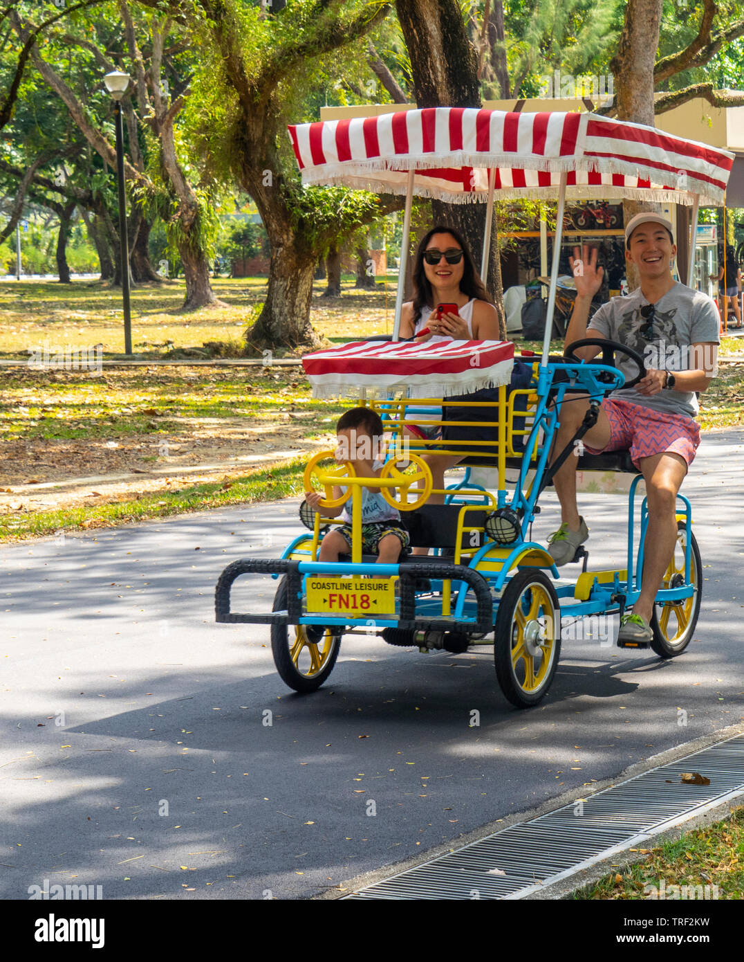Une famille équitation un quad randonnée le long de East Coast Park Singapour. Banque D'Images