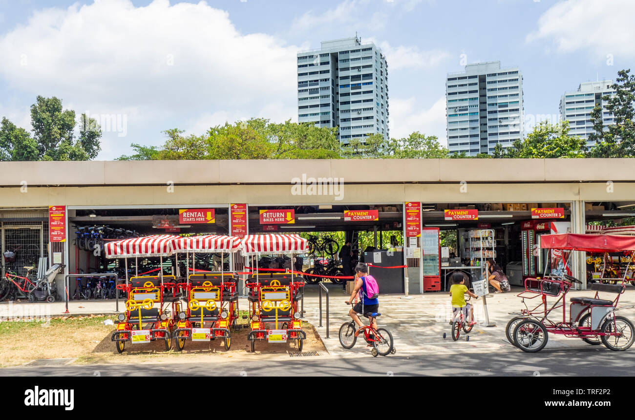 Les garçons la bicyclette avec des roues de formation en face de la location de vélos depot le long de East Coast Park Singapour. Banque D'Images