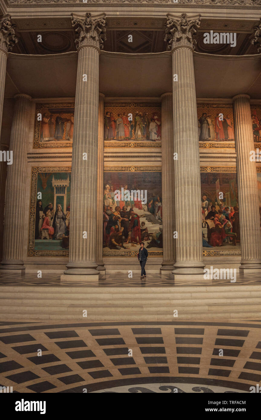 Femme à l'intérieur du Panthéon parmi les hautes colonnes et tableaux à Paris. L'un des plus impressionnants du monde centre culturel en France. Banque D'Images