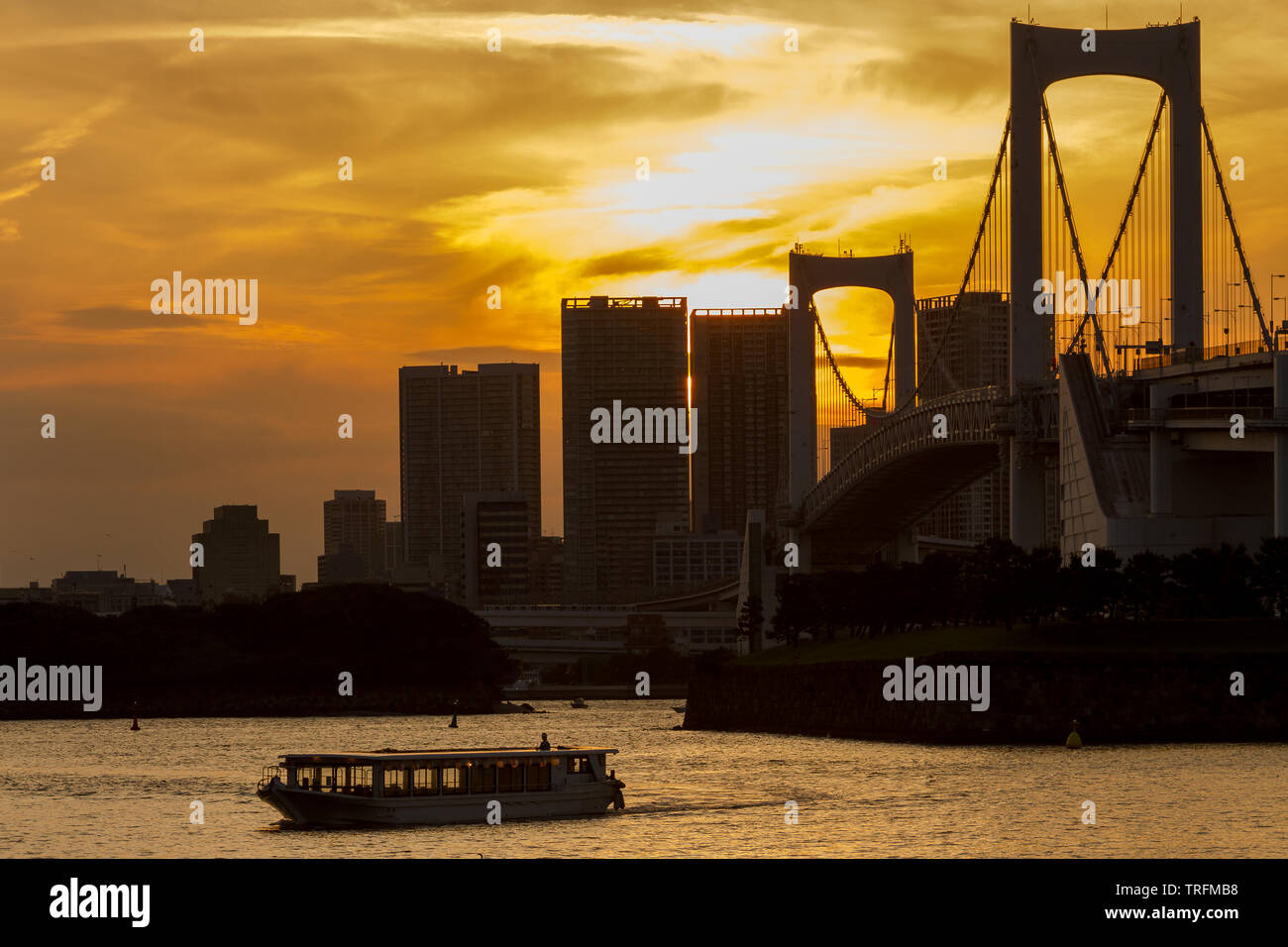 Un bateau de plaisance yakatabune dans la baie de Tokyo au coucher du soleil devant le pont Rainbow, Odaiba, Tokyo, Japon. Banque D'Images Un bateau de plaisance yakatabune dans la baie de Tokyo au coucher du soleil devant le pont Rainbow, Odaiba, Tokyo, Japon. Banque D'Images